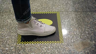 Footprint signs. social distancing. yellow markings on the floor to maintain social distance between people during