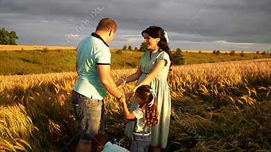 Family with two children standing in field pops air balloon to know the gender of future baby