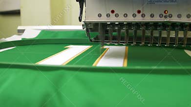 Modern embroidery machine tool makes number on hokey uniform