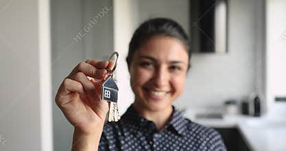 Close up focus on keys in hand of smiling woman.
