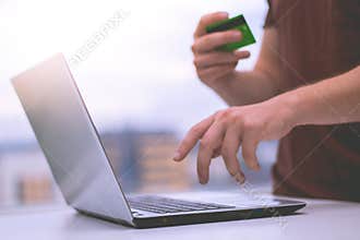 Soft focus of a man's doing online transaction using credit card, e-commerce concept