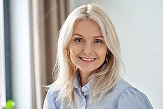 Happy sophisticated middle aged business woman looks at camera, headshot.