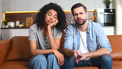Multiracial couple chilling on the couch, watching movie