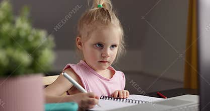 Little girl using laptop computer at home for distance learning or homework