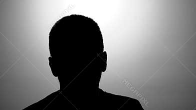 Caucasian men black silhouette against grey wall talking during interview, hidden identity. Secret testimony of crown witness