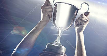 Digital animation of spot of light against man holding a trophy