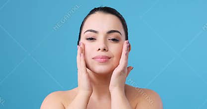 Beautiful woman gently massaging her skin