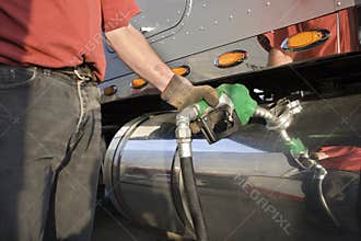 Truck driver pumping gas