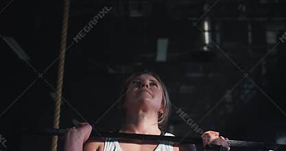 Close-up young muscular strong blonde professional sports woman lifting heavy barbell, working out at modern gym.