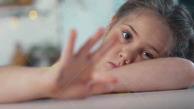 child sad. girl kid a bored home. child autistic child care treatment concept. bored girl taps her fingers on the drain