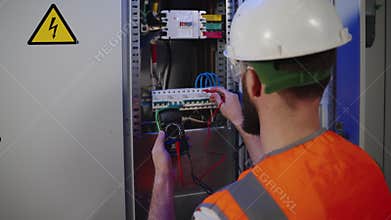 measuring electrical voltage by multimeter, electrician is looking for breakdown