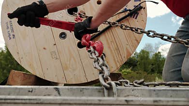 Close up . Cargo shipping. Men workers fasten the load on the truck.