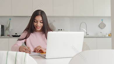 Indian schoolgirl on online lesson using pc laptop computer. Remote homeschool.