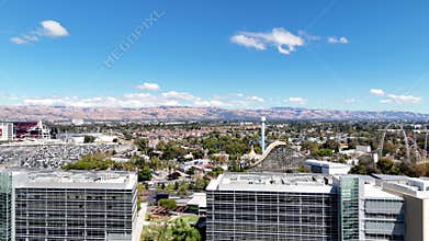 Levi\'s Stadium aerial view in Santa Clara with office buildings, parking lots, and mountains