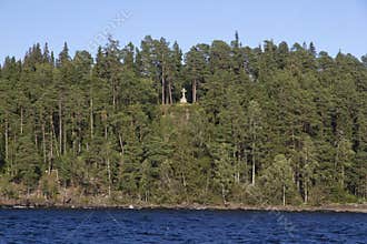 Orthodox worship cross on a slope amidst a coniferous forest