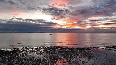 Silhouette of a yacht against the backdrop of a colorful tropical sunset sky at the sea and Fiji Island.