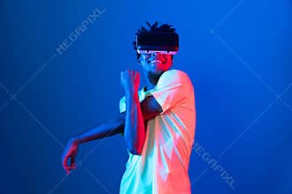 African sport player wearing VR stretching arm neon light wall. Contrivance.