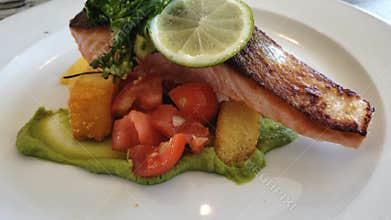 Camera pans to a plate of pan-fried succulent salmon steak