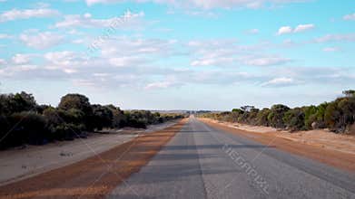 Campervan driving a long road in the Australian Outback in Western Australia. You can see the vast landscape and just