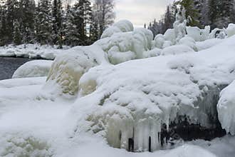 An icy rocky coastline with icicles and snow