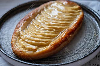 French fresh baked sweet puff pastry with fresh apple fruits in sirup in confectionery shop