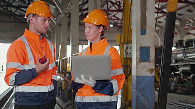 Young caucasian engineer man and woman checking train with laptop in station, team engineer inspect system transport.