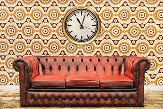 Retro styled image of an old sofa and clock against a vintage wa