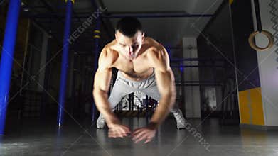 Muscular sportsman doing push at modern gym. Young athlete showing hard and intense workout. Strong sporty man