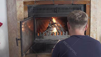 A man makes a fire in a fireplace at home, Spain