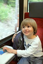Happy boy with backpack on train