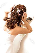 Bride adjusting hair in mirror