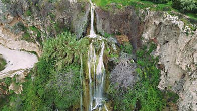 Aerial video of waterfall, travel destination in Turkey, nestled in mountains, surrounded by foliage. Emphasizes