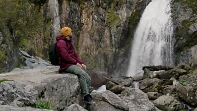Calm Hiking Male Sitting and Relaxing at Beautiful Waterfall Viewpoint Concept