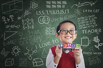 Asian boy student hold learn block in class