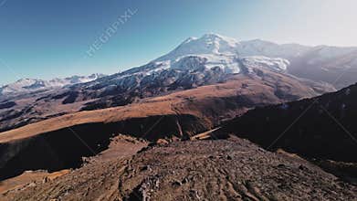 Dive from the top of a rocky mountain down under the rocks. Sport fpv drone flying over rocky mountain slope