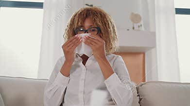 Ill woman wearing glasses sitting on a couch