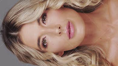 Studio portrait of young and beautiful blond woman over grey background. Skin care and wellness concepts.