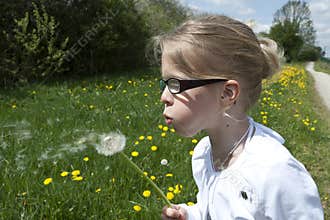 Girl blowing dandelion