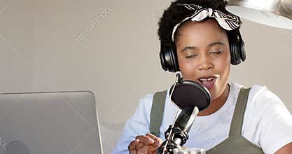 African American woman podcasting with a microphone at home