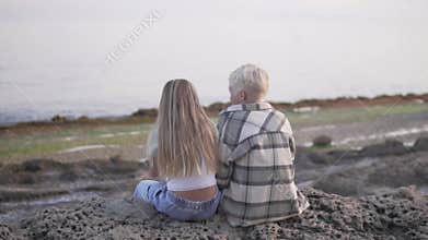 Couple enjoying scenic ocean view from rock, feeling happy and at peace