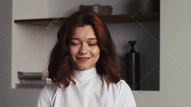 Young woman saying yes by shaking her head at home or modern office