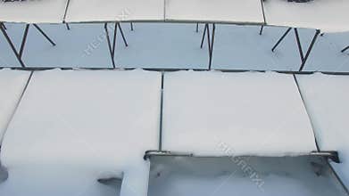 Solar batteries covered by snow at winter day.