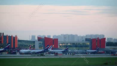 Planes ride at airport terminal, cityscape during