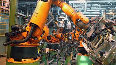 Robots weld car parts in production line at