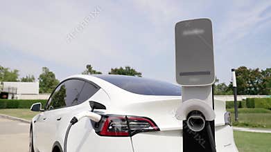 EV electric car recharge battery at parking lot in green city park. Expedient