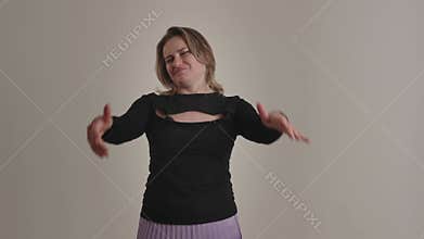 A woman displaying negative and indifferent expressions in front of a simple backdrop