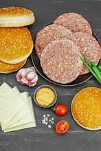 Burger patties. Beef cutlets, buns, vegetables and sauce. Homemade American classic