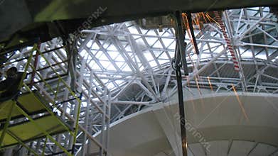 Two man constructing scaffolding and welding