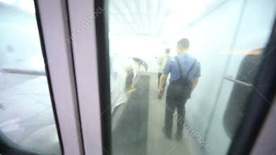 View of painting booth with workers inside through