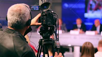 Back of videographer working on press conference